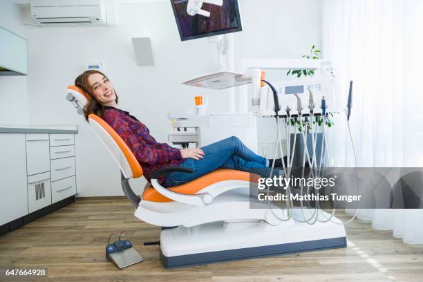 patientin auf dem behandlungsstuhl eines zahnarztes - dentists chair stock-fotos und bilder