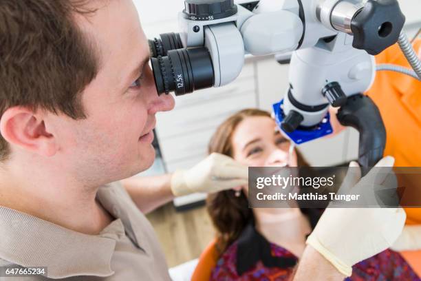 dentist working with his assistant on a patient - zahnarztpraxis stock pictures, royalty-free photos & images