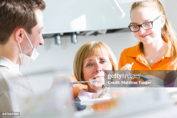behandlung einer älteren patientin beim zahnarzt - patientin stockfoto's en -beelden