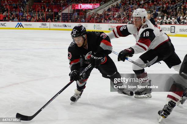 Arizona Coyotes Center Christian Dvorak cross checks Carolina Hurricanes Center Derek Ryan in a game between the Arizona Coyotes and the Carolina...