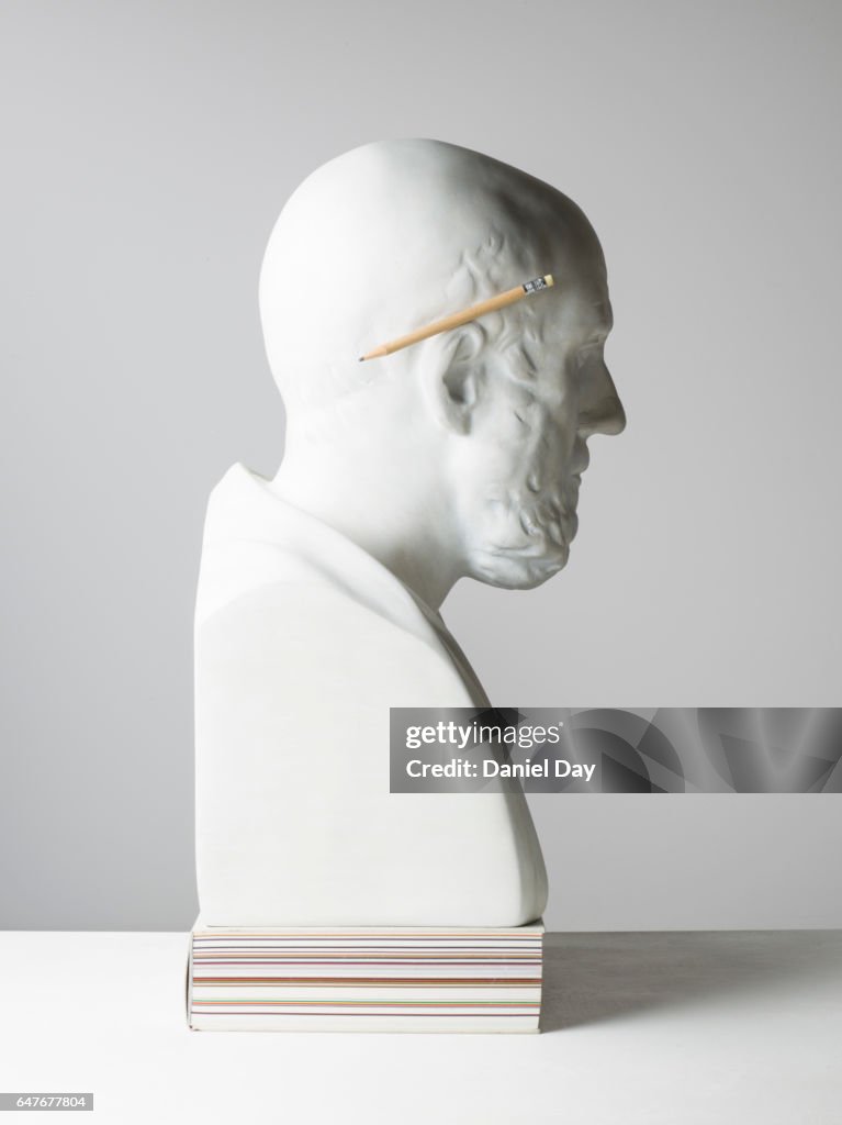 Plaster cast of a man with pencil and glasses
