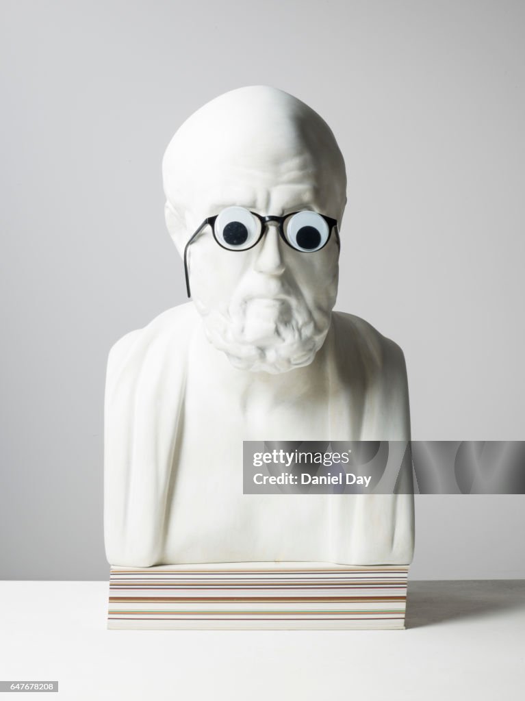 Plaster cast of a man with pencil and glasses