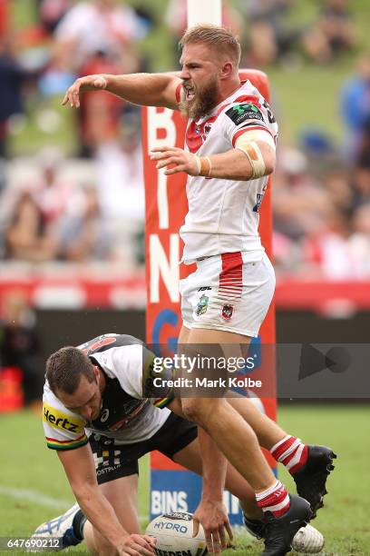 Jack de Belin of the Dragons celebrates scoring a try as Isaah Yeo of the Panthers looks dejected during the round one NRL match between the St...