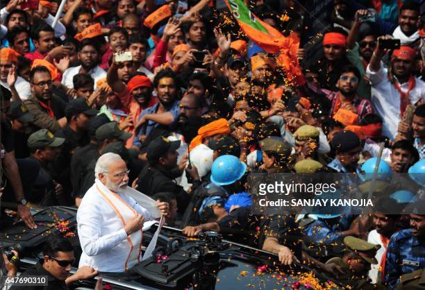 Indian Prime Minister Narendra Modi and leader of the Bharatiya Janata Party gestures during a roadshow in support of their state assembly election...