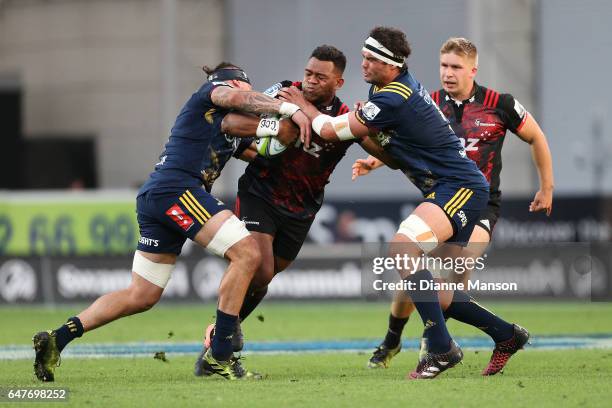 Seta Tamanivalu of the Crusaders tries to break the tackle of Elliot Dixon and Tom Franklin of the Highlanders during the round two Super Rugby match...