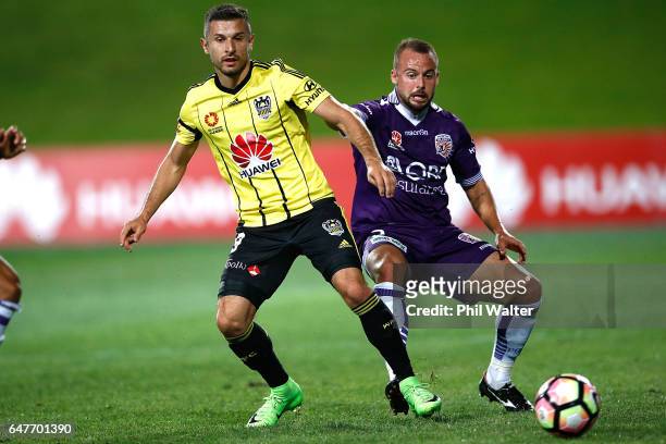 Kosta Barbarouses of Wellington is put under pressure from Marc Warren of Perth during the round 22 A-League match between the Wellington Phoenix and...