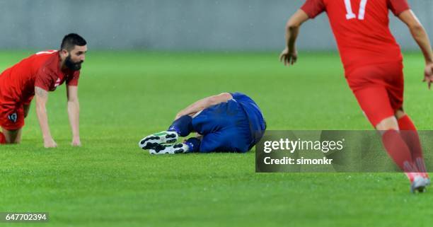 football player injured - football player kneeling stock pictures, royalty-free photos & images