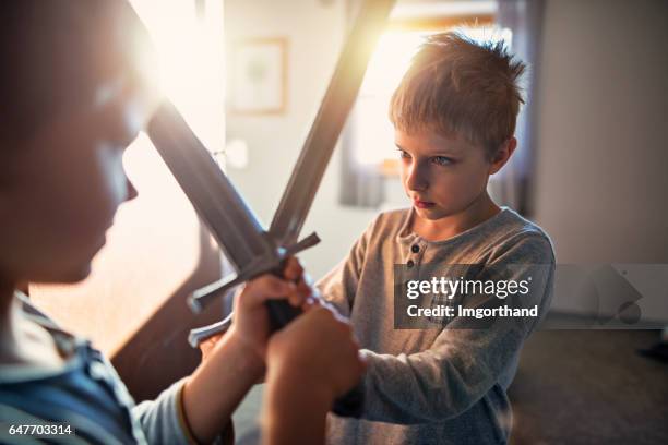 les petits garçons jouent à la maison des chevaliers - sword photos et images de collection