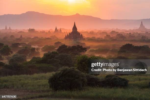 pagodas and the mist at sunset in bagan, mandalay, myanmar - bagan temples damaged in myanmar earthquake stock pictures, royalty-free photos & images