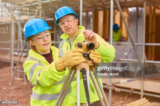 aprendiendo a utilizar el nivel de constructor del trabajador de la construcción - ingeniería civil fotografías e imágenes de stock