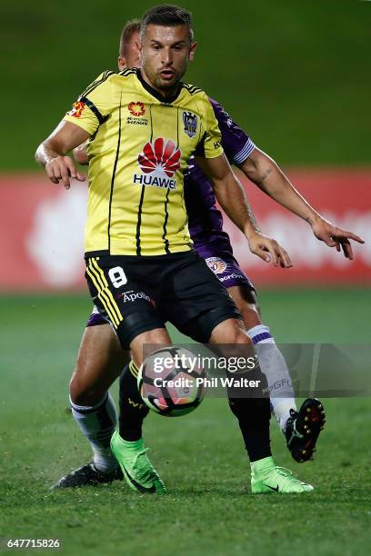 Kosta Barbarouses of Wellington is put under pressure from Marc Warren of Perth during the round 22 A-League match between the Wellington Phoenix and...