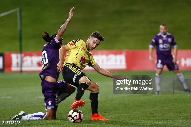 Matthew Ridenton of Wellington is tackled by Aryn Williams of Perth during the round 22 A-League match between the Wellington Phoenix and the Perth...