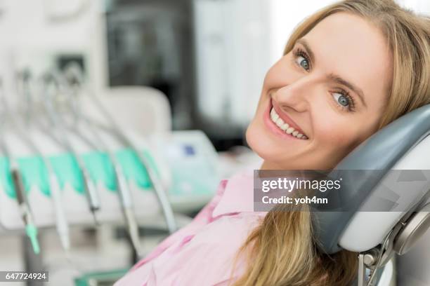 aantrekkelijke jonge vrouw bezoeken tandarts - dentists chair stockfoto's en -beelden