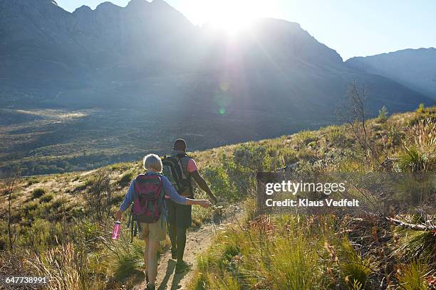 man and woman hiking in the mountains, at sunrise - signaling pathways stock-fotos und bilder