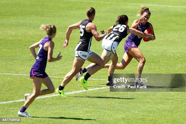 Gemma Houghton of the Dockers attempts to fend off a tackle by Tara Morgan of the Magpies during the round five AFL Women's match between the...