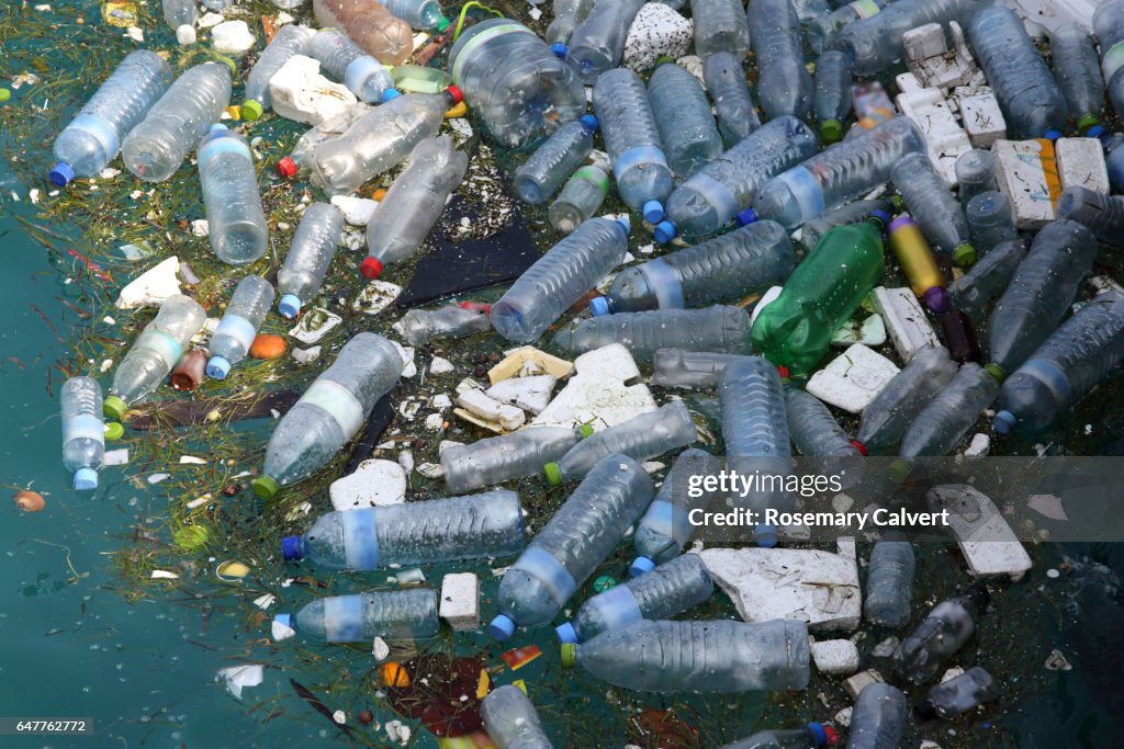 Plastic bottles and polystyrene floating in sea.
