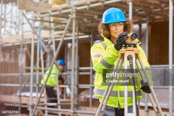 woman construction worker on a building site - geodesy stock pictures, royalty-free photos & images
