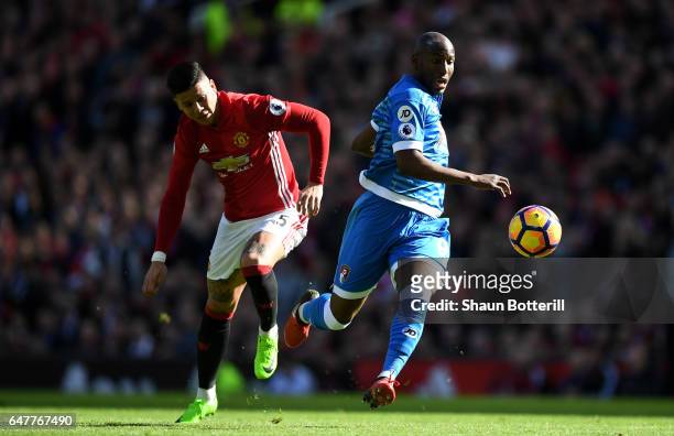 Benik Afobe of AFC Bournemouth slips as he attempts to take the ball past David De Gea of Manchester United while under pressure from Marcos Rojo of...