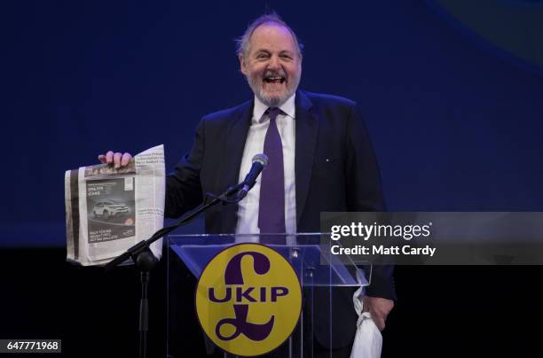 And international trade spokesman William Dartmouth holds a copy of The Times newspaper as he speaks at the UKIP South West regional conference at...