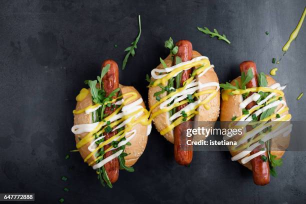 three hot dogs with mustard, mayonnaise and arugula - bbq sandwich stockfoto's en -beelden