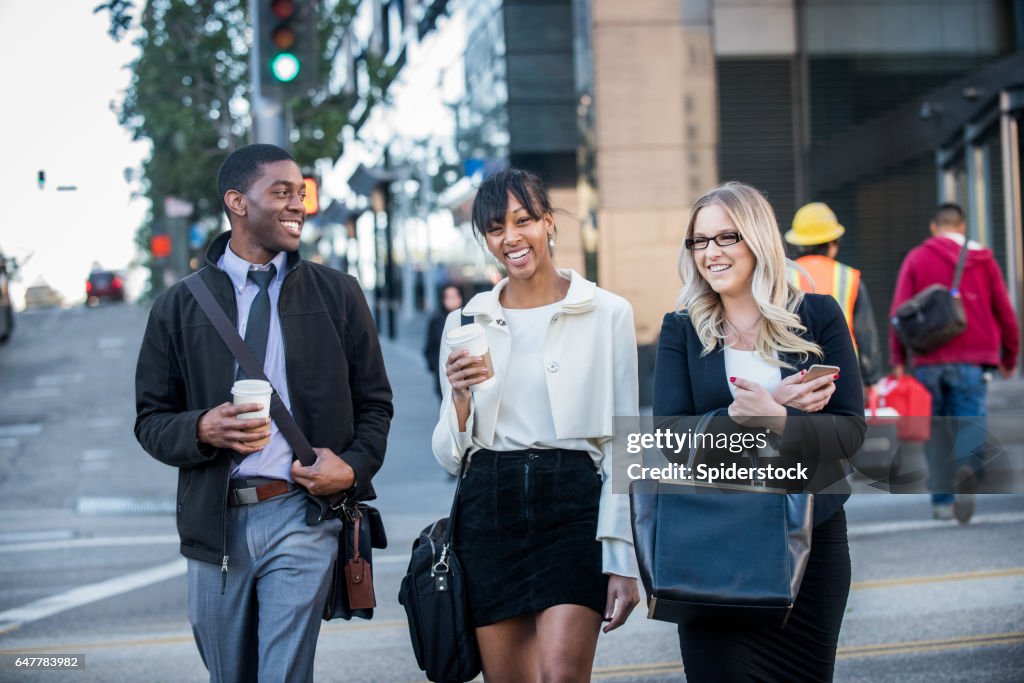 Tres Multi étnicos milenarios en traje de negocios con café en el centro de la ciudad de Los Angeles