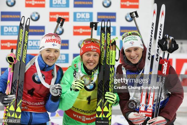 Second place Kaisa Makarainen of Finland first place Laura Dahlmeier of Germany and third place Anais Bescond of France celebrate during the flower...