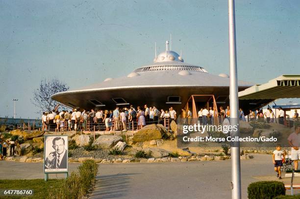 View of visitors waiting on line outside the Braniff Airways Space Ship flying saucer attraction in the Satellite City exhibit at the Freedomland USA...