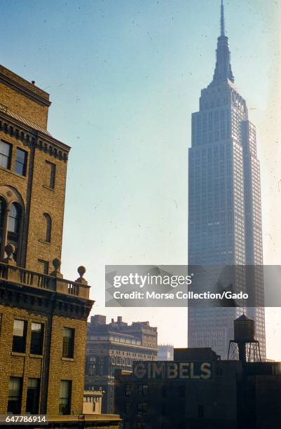 View facing northeast of the Empire State Building at 34th Street and Fifth Avenue in Manhattan, New York City, 1957. In the foreground a warehouse...