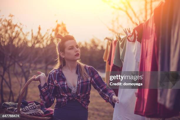 lovely retro styled girl with a basked filled wtih laundy - clothes wringer stock pictures, royalty-free photos & images