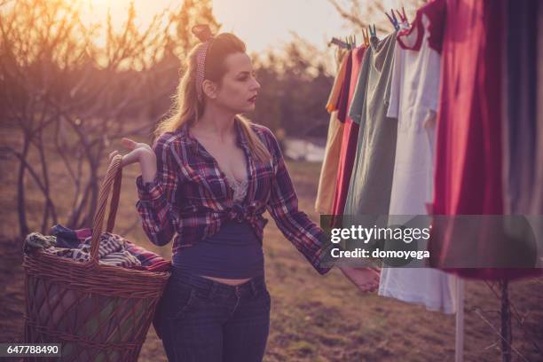 beautiful vintage styled girl doing laundry - clothes wringer stock pictures, royalty-free photos & images