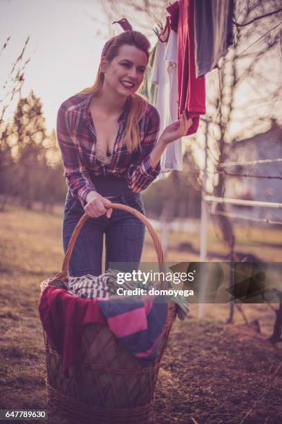 lovely retro styled girl with a basked filled wtih laundy - clothes wringer stock pictures, royalty-free photos & images