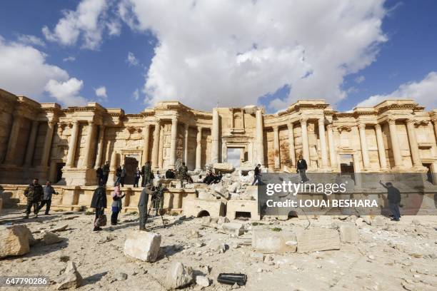 Picture taken on March 4, 2017 shows journalists at the site of the damaged Roman amphitheatre in the ancient city of Palmyra in central Syria, as...