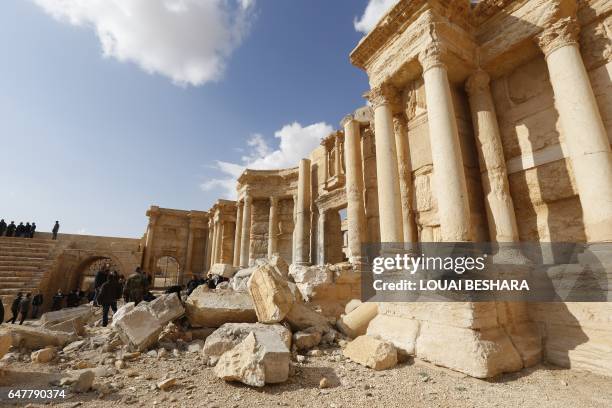 Picture taken on March 4, 2017 shows journalists at the site of the damaged Roman amphitheatre in the ancient city of Palmyra in central Syria, as...