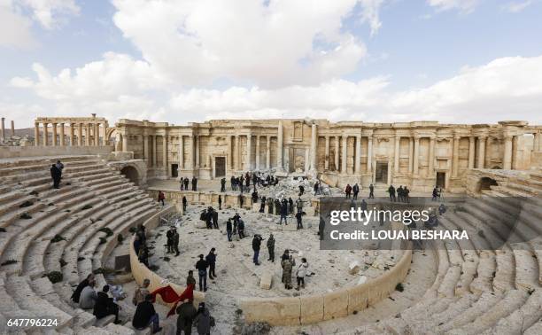 Picture taken on March 4, 2017 shows journalists at the site of the damaged Roman amphitheatre in the ancient city of Palmyra in central Syria, as...