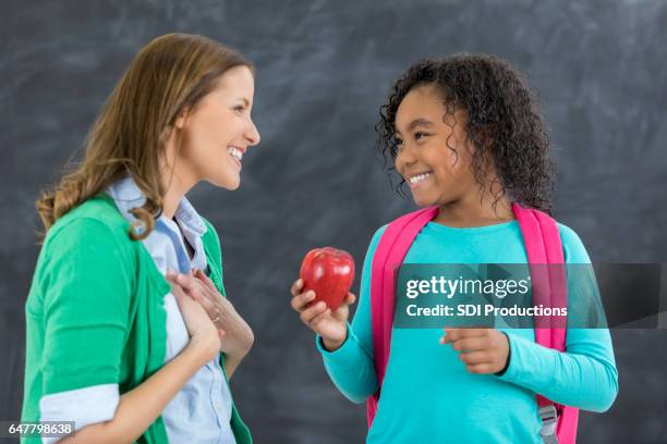 étudiant bien pensé donne enseignant une pomme - kids play apple photos et images de collection