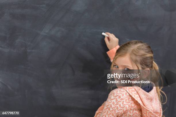 pretty girl writes something on chalkboard at school - child writing on chalkboard stock pictures, royalty-free photos & images