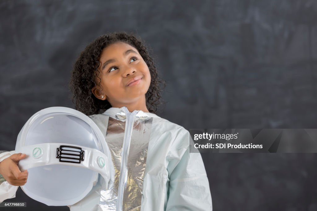 Pretty schoolgirl in astronaut costume