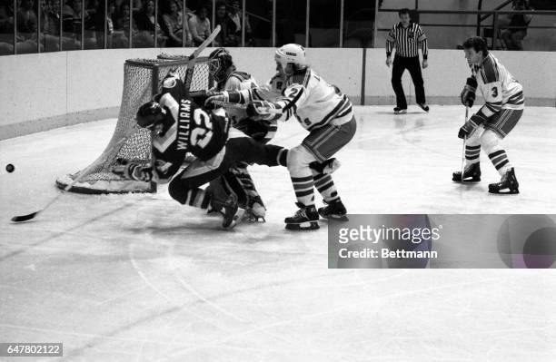 New York Rangers’ goalie Ed Mio and defense men Tom Laidlaw take Tiger Williams of the Vancouver Canucks out of the play 1/7. The Rangers handed the...