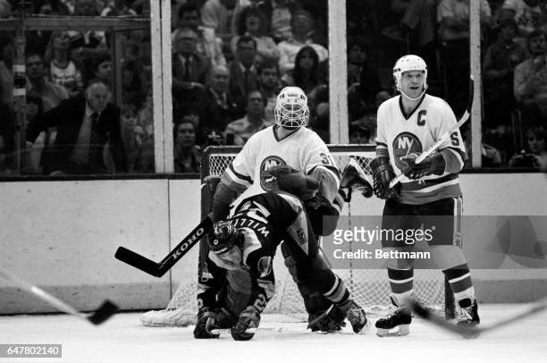 Vancouver’s Tiger Williams takes a spill in front of Islanders’ goalie Billy Smith during the third period of game 5/11. Islanders won 6-4 to take...
