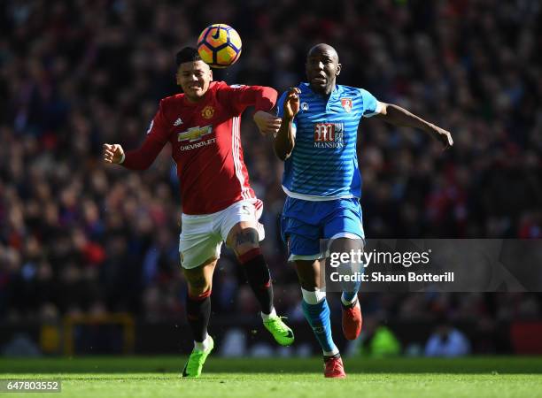 Benik Afobe of AFC Bournemouth is challenged by Marcos Rojo of Manchester United during the Premier League match between Manchester United and AFC...