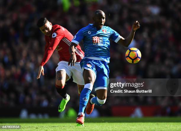 Benik Afobe of AFC Bournemouth is challenged by Marcos Rojo of Manchester United during the Premier League match between Manchester United and AFC...