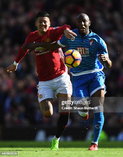 Benik Afobe of AFC Bournemouth is challenged by Marcos Rojo of Manchester United during the Premier League match between Manchester United and AFC...