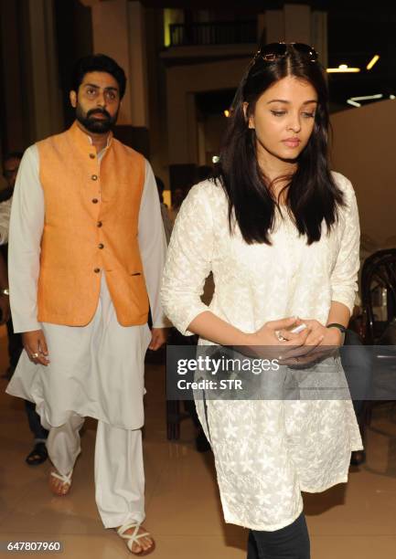 Indian Bollywood actor Abhishek Bachchan walks with his wife actress Aishwarya Rai Bachchan as they attend a prayer meeting for Veerappa Shetty, the...