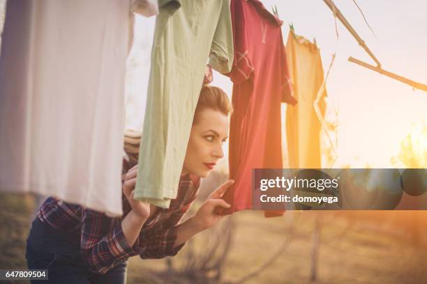 girl has a laundry day outdoors - clothes wringer stock pictures, royalty-free photos & images