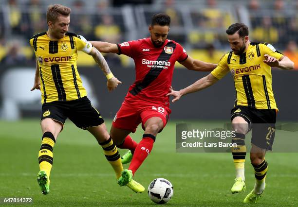 Marco Reus of Dortmund and Gonzalo Castro of Dortmund challenge Karim Bellarabi of Bayer Leverkusen during the Bundesliga match between Borussia...