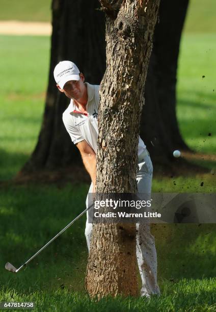 Garth Mulroy of South Africa plays his second shot on the 18th hole from behind a tree during the third round of the Tshwane Open at Pretoria Country...