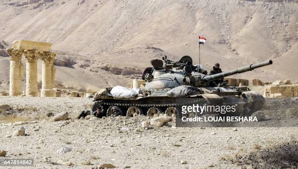Picture taken on March 4, 2017 shows a Syrian army T-62 tank at the damaged site of the ancient city of Palmyra in central Syria. Syrian troops...