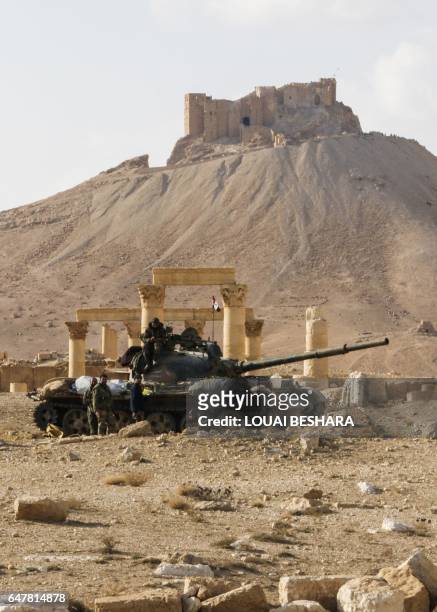 Picture taken on March 4, 2017 shows a Syrian army T-62 tank at the damaged site of the ancient city of Palmyra in central Syria, with the...