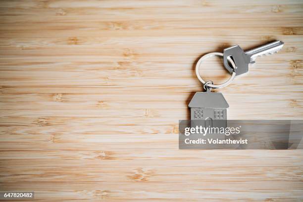 house key on a bamboo table with copy space - keyring charm stock pictures, royalty-free photos & images