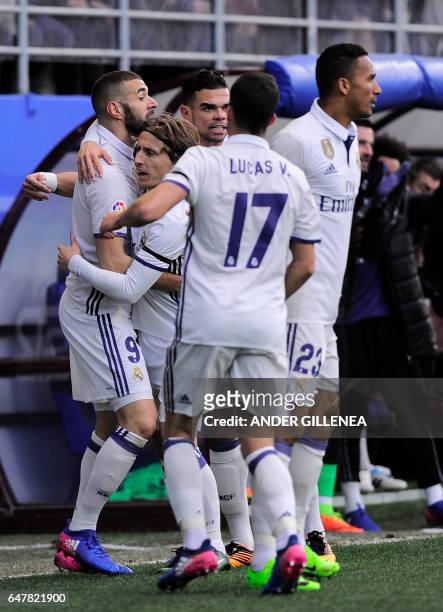 Real Madrid's French forward Karim Benzema celebrates with Real Madrid's Croatian midfielder Luka Modric and teammates after scoring their team's...